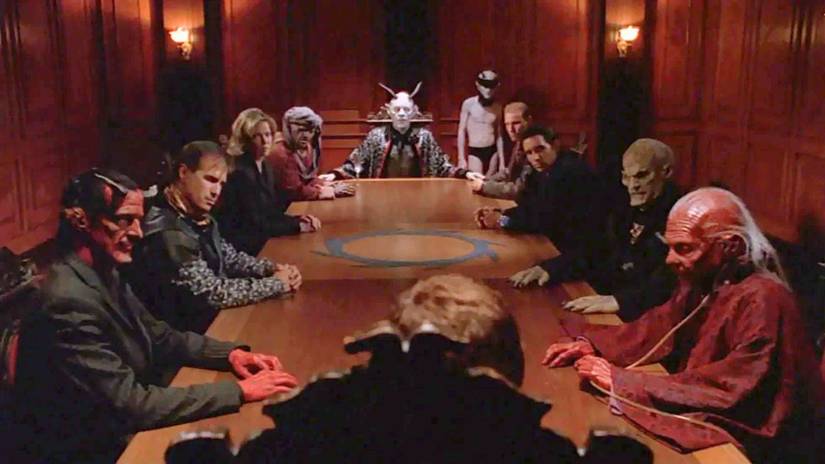 A council of humans and demons sit around a large ornate table in Angel
