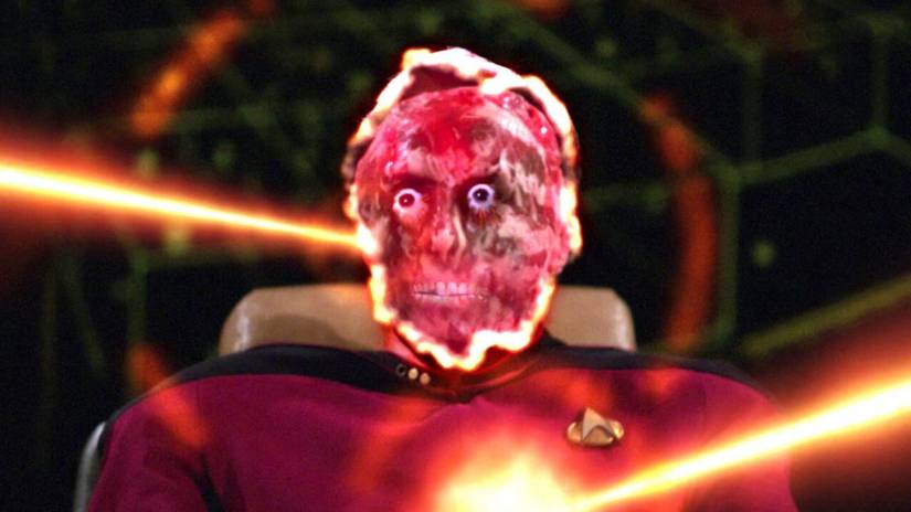 A Starfleet officer's skeletal face is illuminated as he is hit with two phaser blasts in Star Trek: The Next Generation