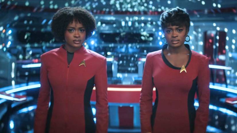 Present Uhura and Future Uhura look at the camera while onn the bridge of the Enterprise in Star Trek: Strange New Worlds