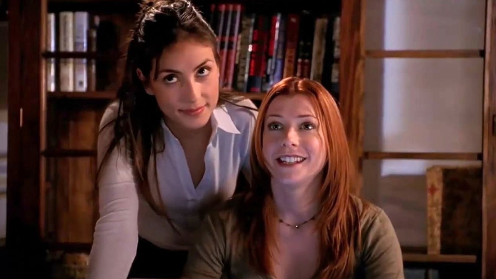 Kennedy leans over Willow's shoulder while Willow is sat at her desk in Buffy the Vampire Slayer Season 7