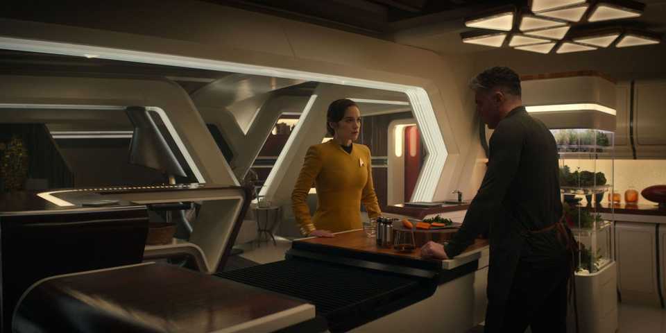 captain-marie-batel-melanie-scrofano-and-captain-christopher-pike-anson-mount-face-each-other-from-opposite-sides-of-pike-s-kitchen-counter-in-star-trek-strange-new-worlds-ad-astra-per-aspera.jpg