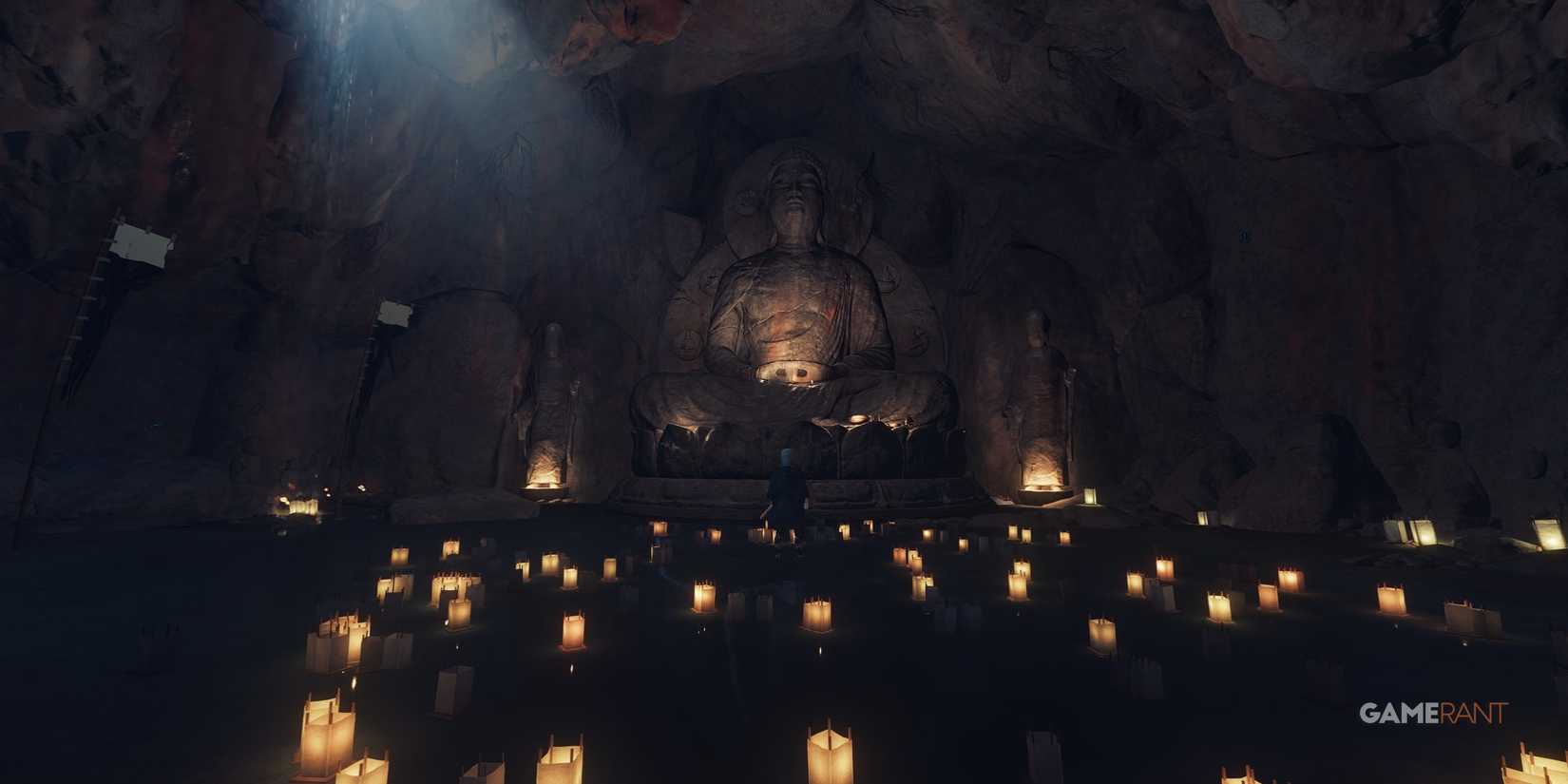 omi monastery cave with lit candles floating on water and a big statue in the background