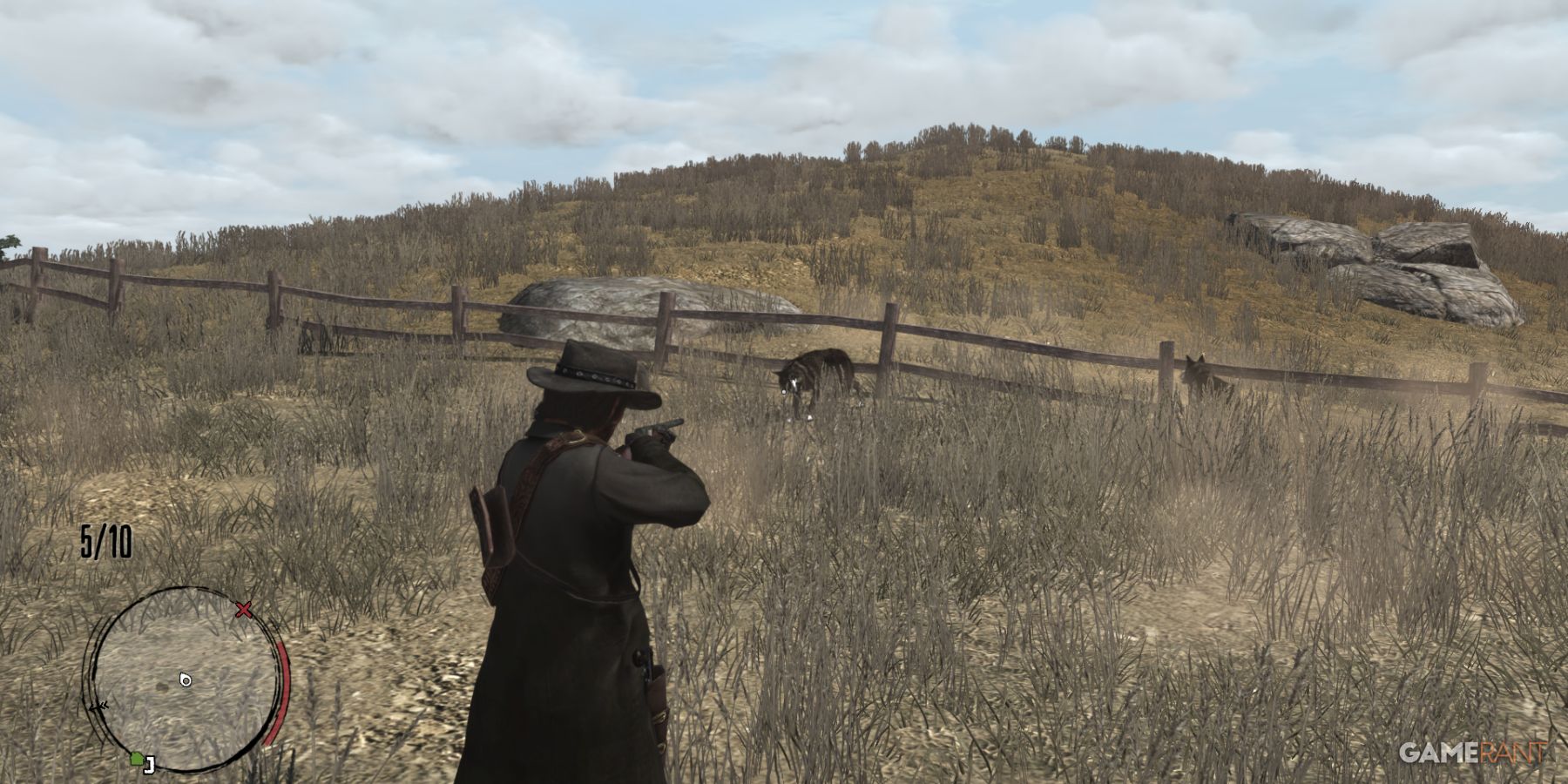 Character aiming a gun at a coyote near a fence in Red Dead Redemption