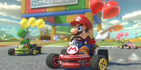 Mario inthe video game Mario Kart 8 Deluxe is driving a car with another Mario Kart 8 Deluxe character at the back. 