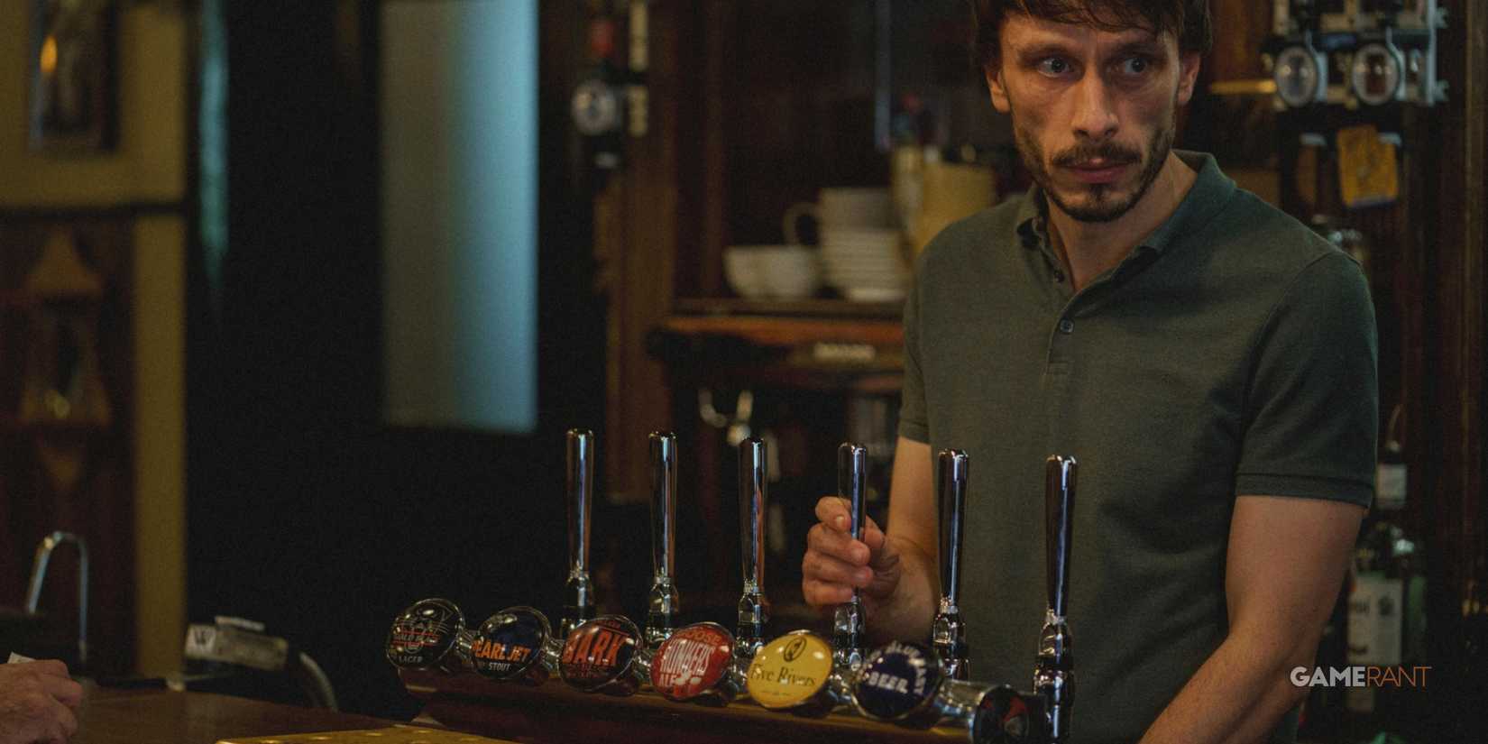 a bartender looking at the direction of the bar entrance in the series baby reindeer-1