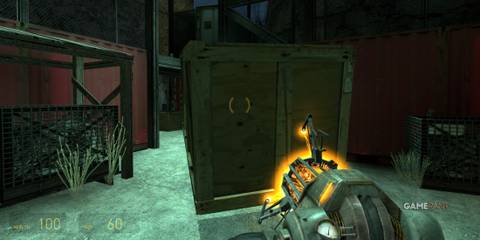 Gravity Gun interacting with a wooden crate in an industrial area in Half-Life 2