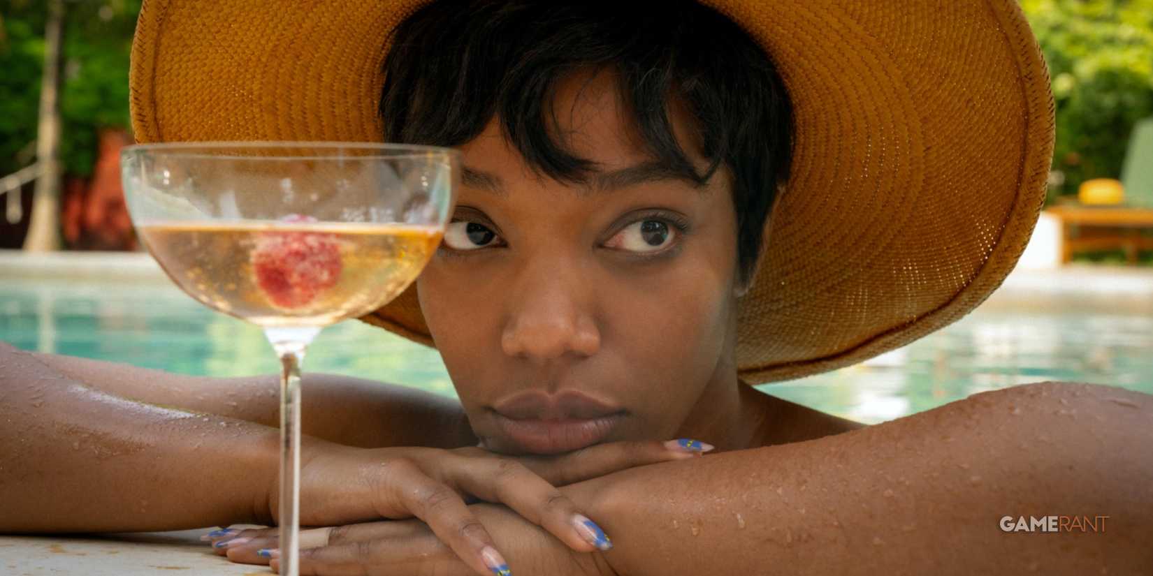 Naomi Ackie in Blink Twice by the pool drinking a cocktail