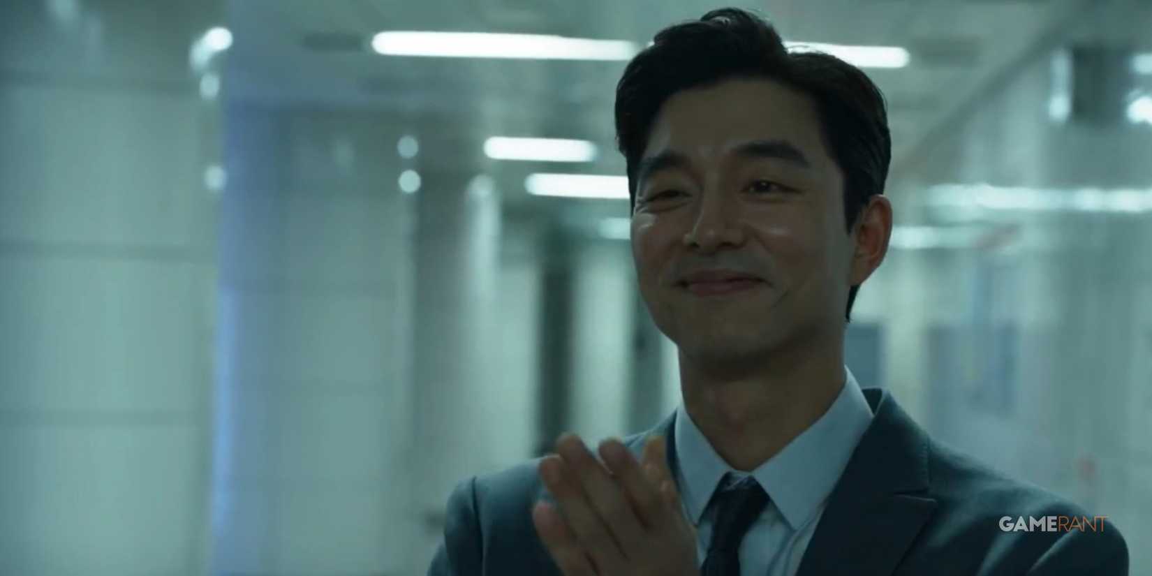 the recruiter from squid game season 2 inside the train station with a proud smile on his face