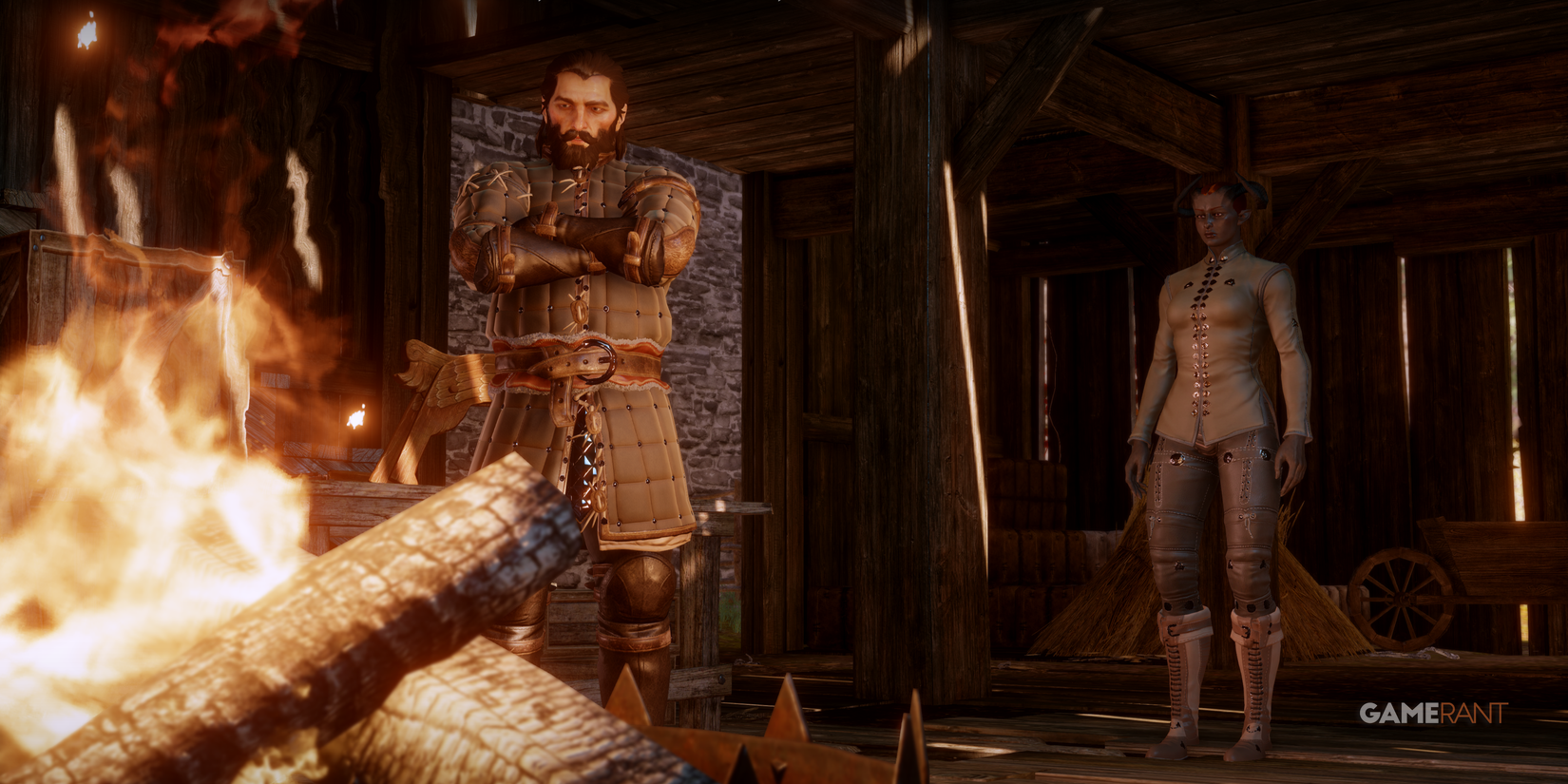 Blackwall stands in front of the fire in the barn with Inquisitor Adaar behind him