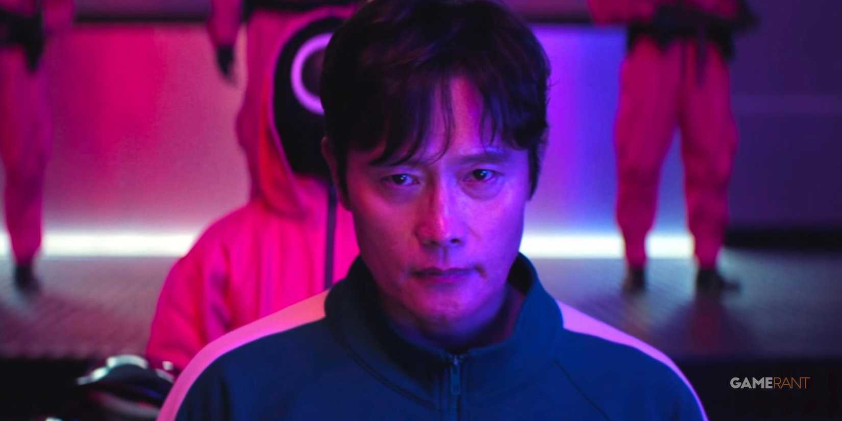 the frontman in season 2 of squid games in a pink medium lit room