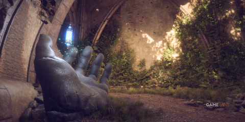 The palm of a fallen statue's hand seemingly gestures toward an ancient light