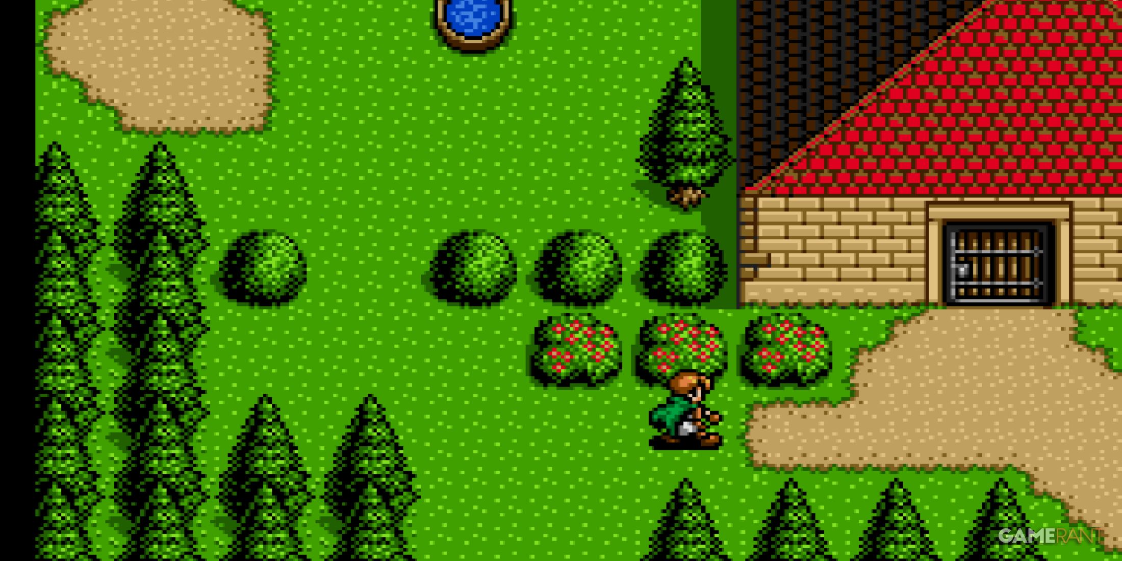 A character walks near bushes and trees outside a house with a red roof in Shining Force 2